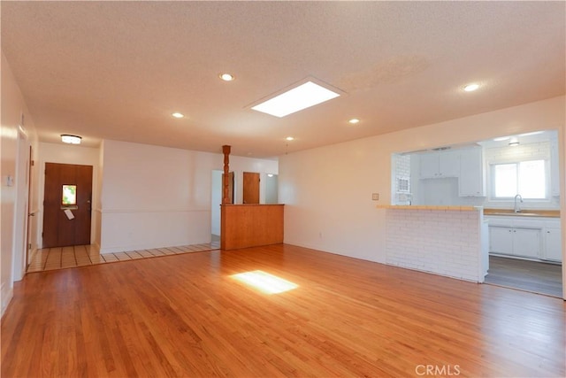 11618 Cedarvale St, Norwalk, CA 90650 - unfurnished living room featuring light wood finished floors, a sink, and recessed lighting
