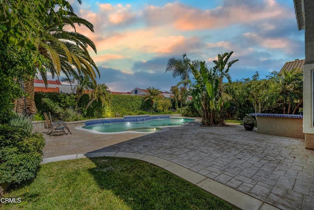 pool at dusk featuring a patio
