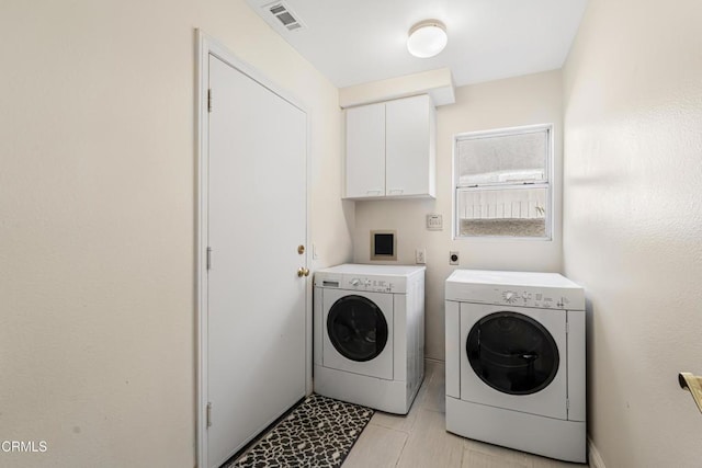 washroom with separate washer and dryer, cabinet space, and light tile patterned floors