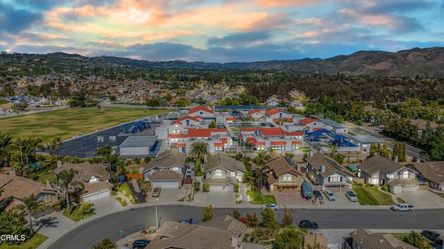 aerial view of property and surrounding area featuring a mountainous background and nearby suburban area