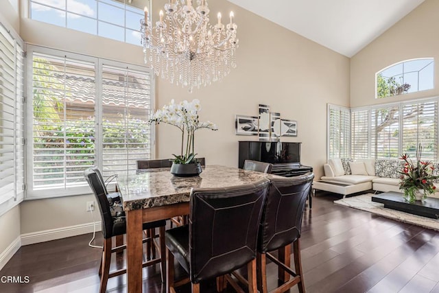 dining room featuring high vaulted ceiling, plenty of natural light, a chandelier, dark wood-style floors, and baseboards