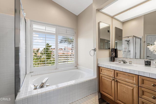 bathroom with a stall shower, a bath, vanity, tile patterned floors, and vaulted ceiling