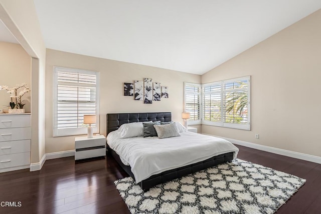 bedroom featuring dark wood finished floors, multiple windows, baseboards, and vaulted ceiling