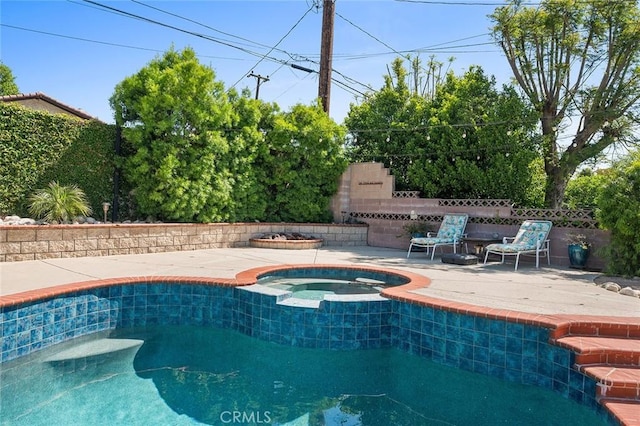 view of pool featuring a patio area, fence, and a pool with connected hot tub