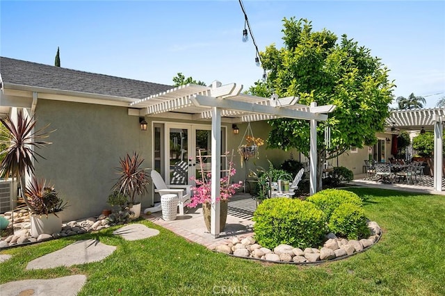 back of property with a pergola, stucco siding, french doors, a lawn, and a patio area