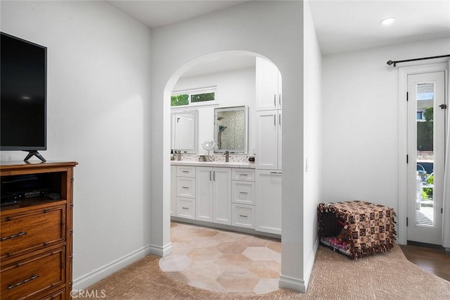 full bath with plenty of natural light, vanity, and baseboards