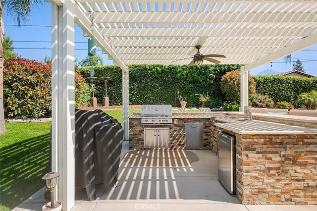 view of patio / terrace with a grill, a ceiling fan, exterior kitchen, and a pergola