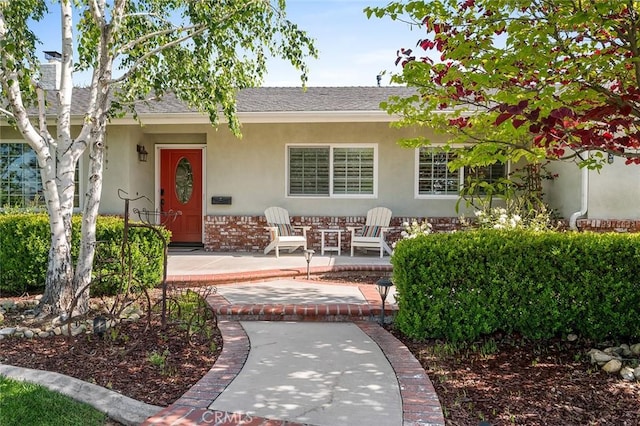 view of front of home featuring stucco siding and a shingled roof