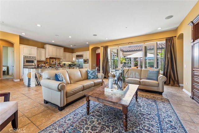 7940 Choi Dr, Riverside, CA 92506 - living room featuring arched walkways, baseboards, recessed lighting, and stone tile flooring
