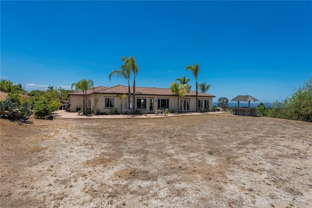 7940 Choi Dr, Riverside, CA 92506 - back of house with a tiled roof, stucco siding, and a patio