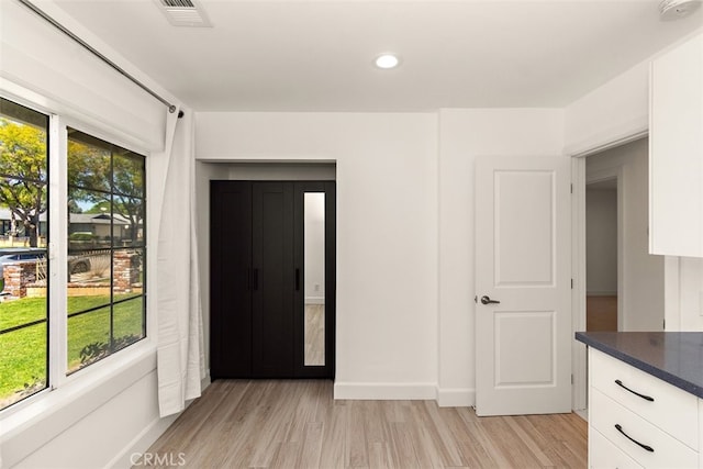 interior space with light wood finished floors, baseboards, and recessed lighting
