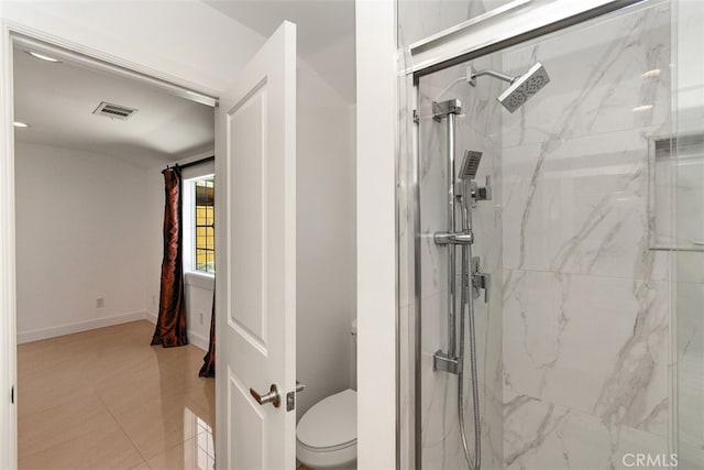 bathroom featuring a marble finish shower, toilet, and baseboards