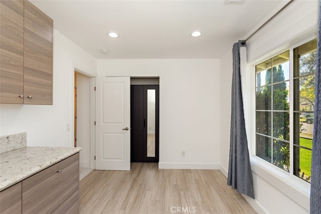 unfurnished dining area featuring light wood-style floors, baseboards, and recessed lighting