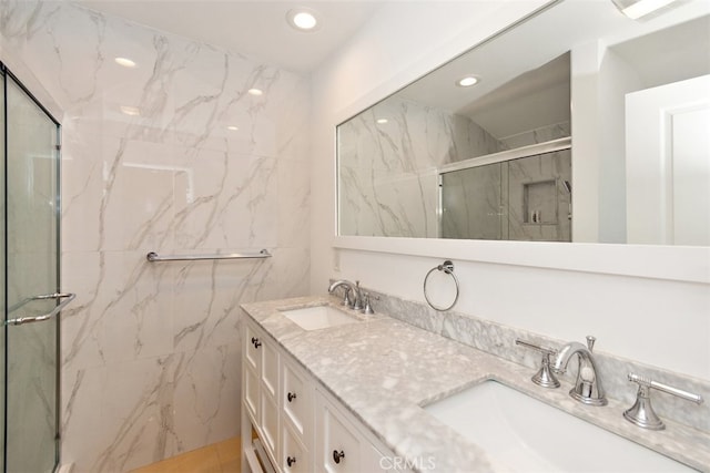 full bathroom featuring a marble finish shower, recessed lighting, and double vanity
