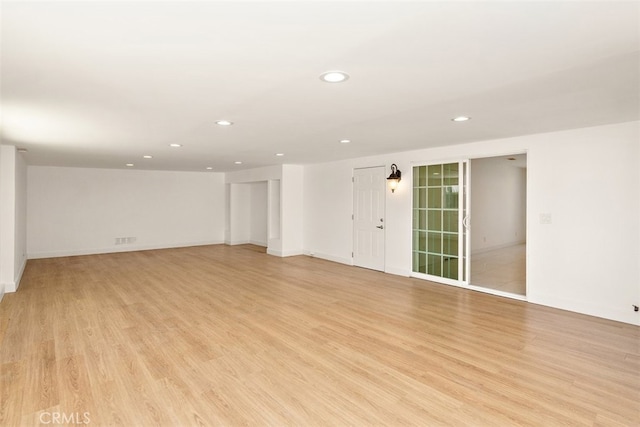 unfurnished room featuring recessed lighting, light wood-type flooring, and baseboards