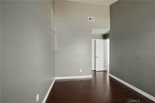 unfurnished room featuring dark wood-style floors and baseboards