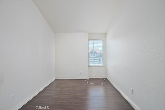 unfurnished room with baseboards and wood finished floors