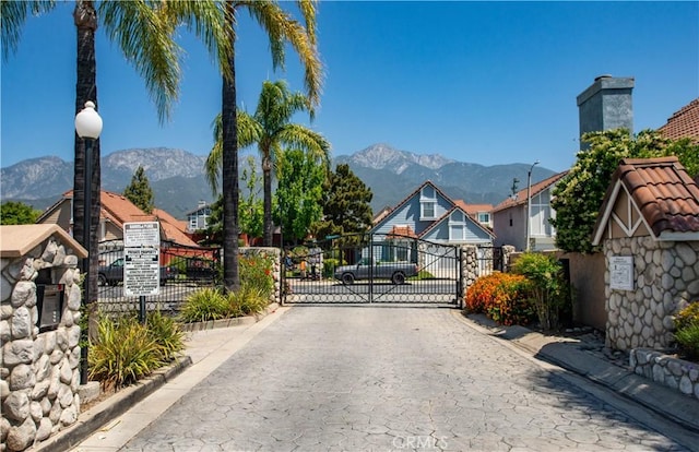 9788 Balaton St, Rancho Cucamonga, CA 91737 - view of road featuring a gate, a mountain view, curbs, and a gated entry