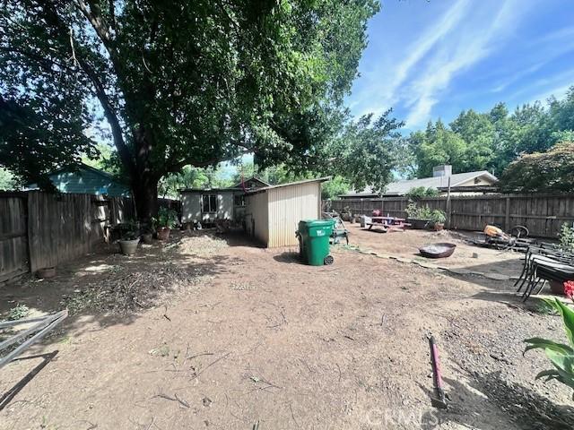 1414 Almond St, Chico, CA 95928 - fenced backyard featuring a shed and an outbuilding