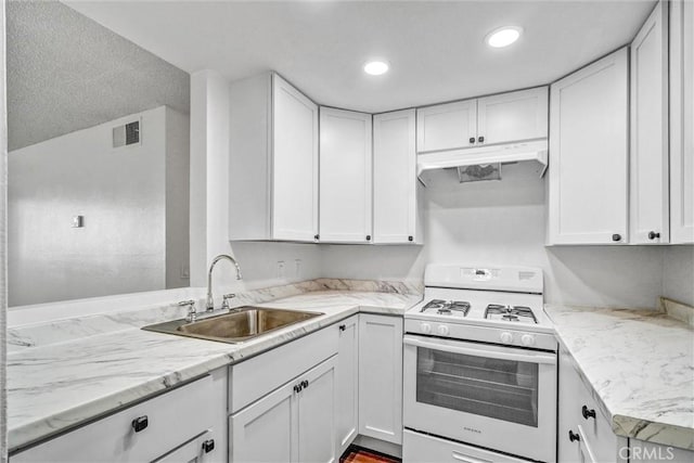 600 W 3rd St Unit A115, Santa Ana, CA 92701 - kitchen with white gas stove, a sink, under cabinet range hood, white cabinets, and recessed lighting