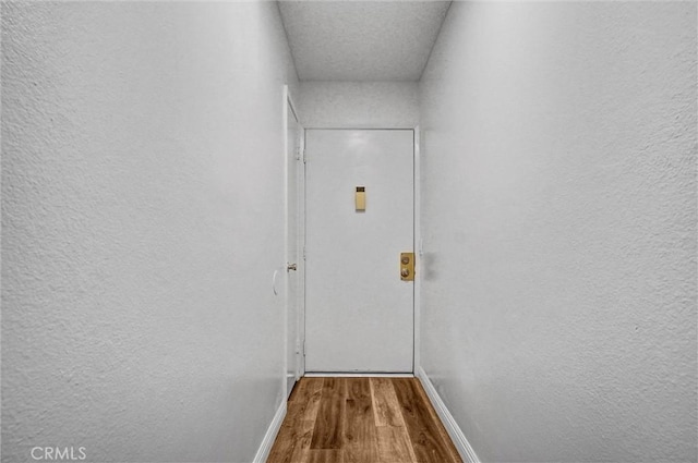 600 W 3rd St Unit A115, Santa Ana, CA 92701 - doorway to outside with wood finished floors, baseboards, and a textured wall