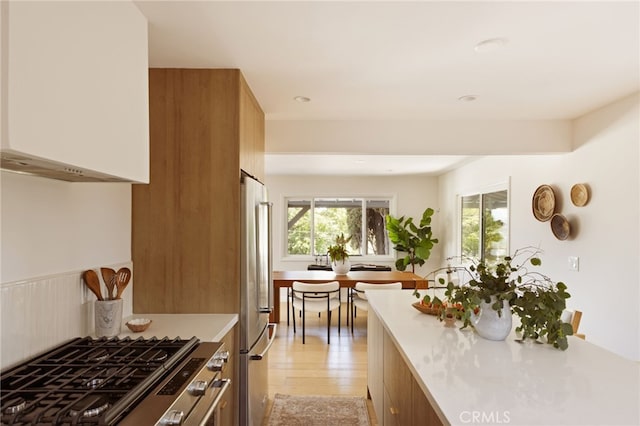 479 Crane Blvd, Los Angeles, CA 90065 - kitchen with high end refrigerator, light countertops, stovetop, light wood-style flooring, and brown cabinetry