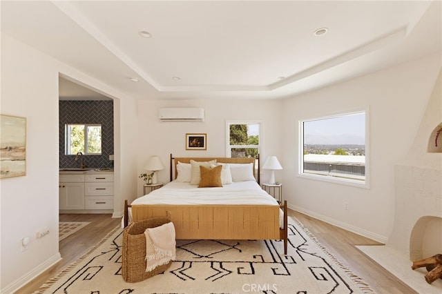 479 Crane Blvd, Los Angeles, CA 90065 - bedroom featuring a wall mounted air conditioner, light wood-type flooring, a raised ceiling, and multiple windows