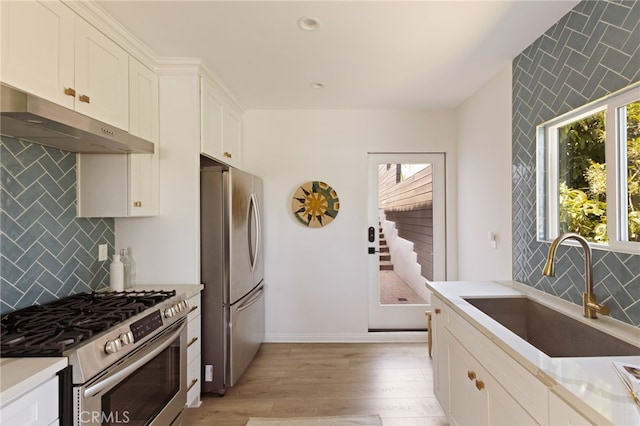 479 Crane Blvd, Los Angeles, CA 90065 - kitchen featuring stainless steel appliances, under cabinet range hood, a sink, light wood-type flooring, and white cabinets