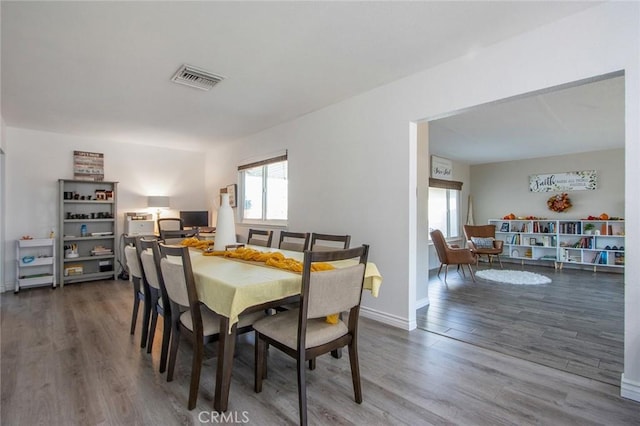 dining area with plenty of natural light, wood finished floors, and baseboards