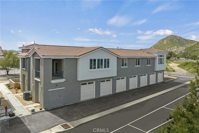 986 Coriander Dr Unit 304, Hemet, CA 92545 - view of front of property featuring stucco siding, asphalt driveway, a tile roof, and cooling unit
