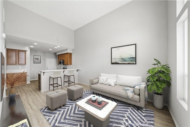 986 Coriander Dr Unit 304, Hemet, CA 92545 - living room with light wood finished floors, baseboards, a towering ceiling, and recessed lighting