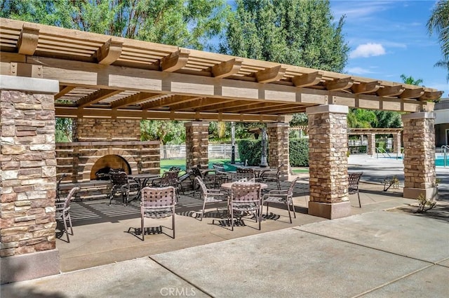 986 Coriander Dr Unit 304, Hemet, CA 92545 - view of patio / terrace featuring an outdoor stone fireplace, a pergola, and fence