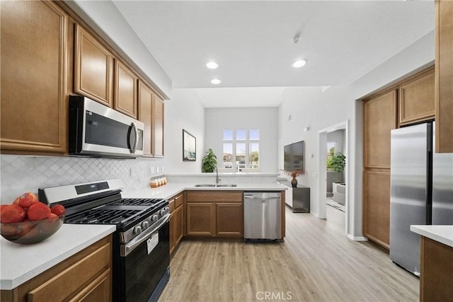 986 Coriander Dr Unit 304, Hemet, CA 92545 - kitchen featuring stainless steel appliances, a sink, light wood-style floors, decorative backsplash, and light countertops