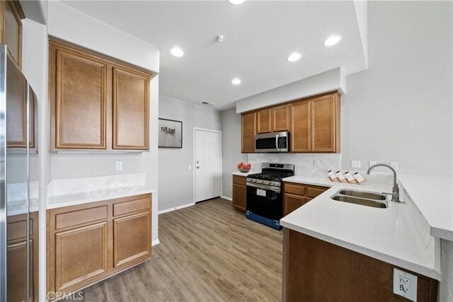 986 Coriander Dr Unit 304, Hemet, CA 92545 - kitchen featuring stainless steel appliances, a sink, light wood finished floors, light countertops, and a peninsula