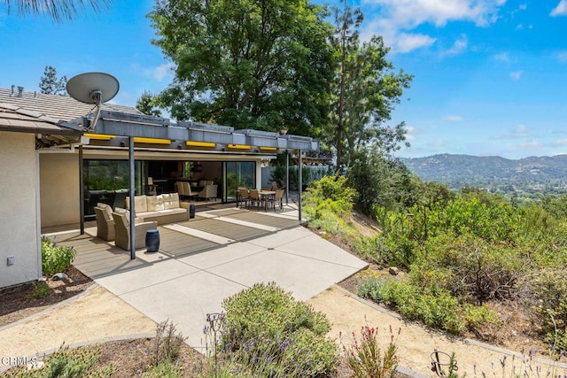 view of patio / terrace featuring an outdoor living space, a mountain view, and outdoor dining area