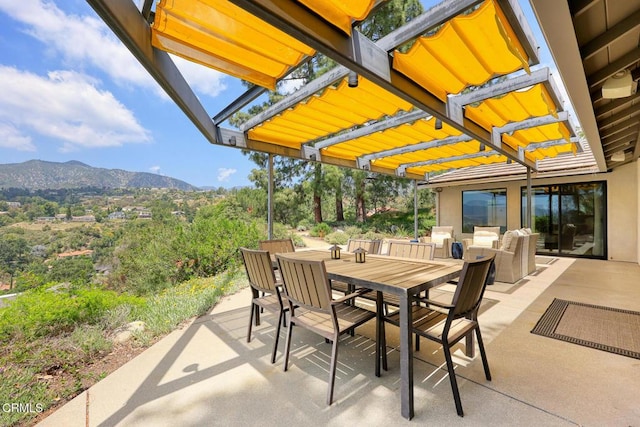 view of patio with a mountain view and outdoor dining area