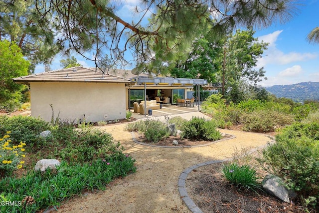 rear view of property with stucco siding, a patio, and a mountain view