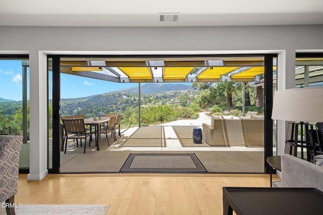 doorway to outside with a mountain view and wood finished floors
