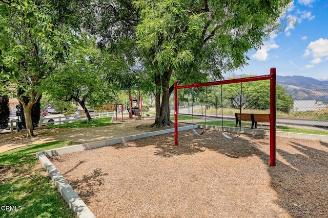 community jungle gym with fence and a mountain view