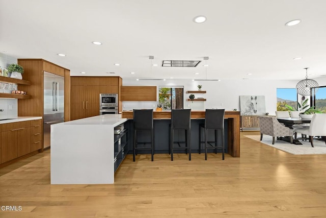 kitchen with modern cabinets, built in appliances, open shelves, brown cabinets, and recessed lighting