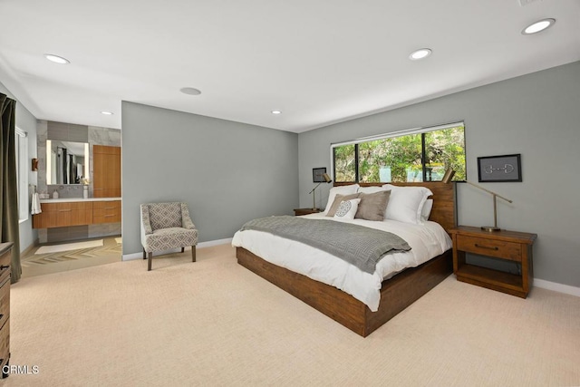 bedroom featuring light colored carpet, recessed lighting, baseboards, and ensuite bath