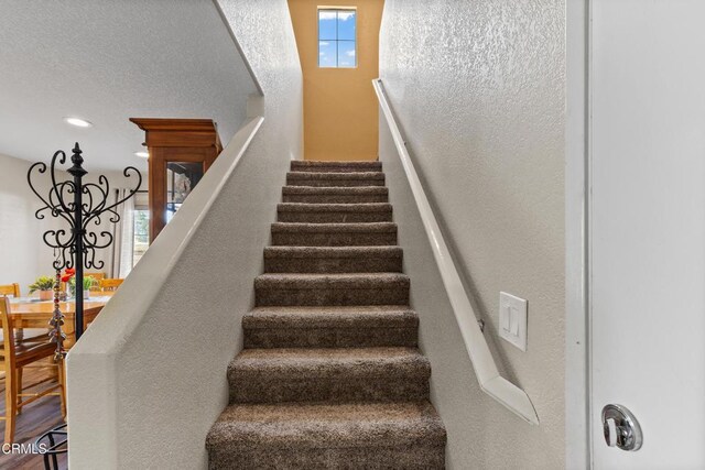 2024 Green Ridge Cir, Lompoc, CA 93436 - stairway featuring a chandelier and a textured wall
