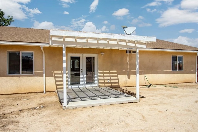 6649 Pine Spring Ave Unit 29, Palms, CA 92277 - back of property featuring french doors, stucco siding, and roof with shingles