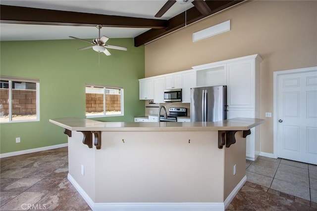 6649 Pine Spring Ave Unit 29, Palms, CA 92277 - kitchen featuring appliances with stainless steel finishes, ceiling fan, high vaulted ceiling, a kitchen breakfast bar, and baseboards
