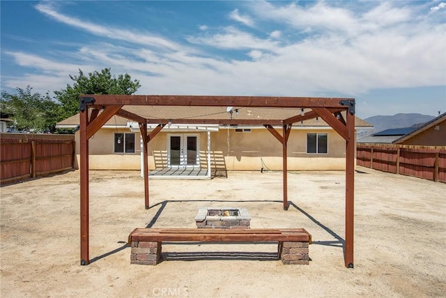 6649 Pine Spring Ave Unit 29, Palms, CA 92277 - back of house featuring french doors, a fire pit, a fenced backyard, and a patio area