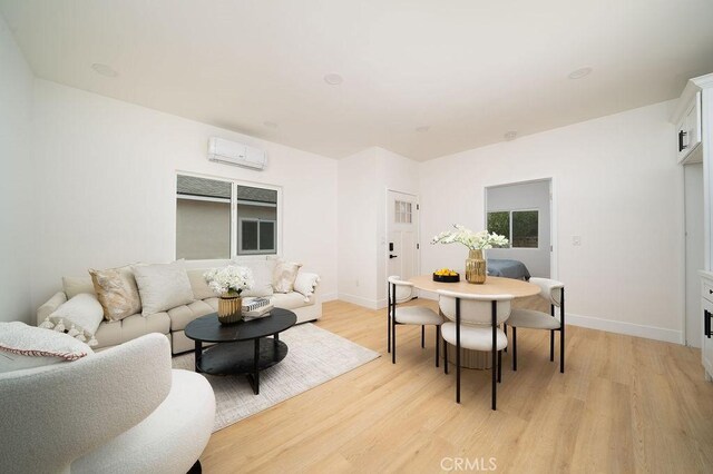 13282-13280 Nevada St, Westminster, CA 92683 - living area with an AC wall unit, light wood-style flooring, and baseboards
