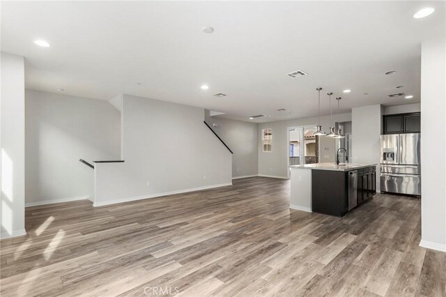 26703 Lexington Ln, Saugus, CA 91350 - kitchen with stainless steel appliances, open floor plan, a sink, light countertops, and light wood finished floors