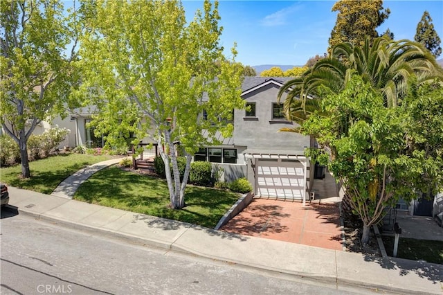 810 Meinecke Ave, San Luis Obispo, CA 93405 - view of property hidden behind natural elements with stucco siding, a front lawn, concrete driveway, and a garage