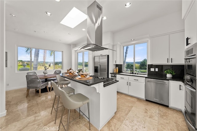 4462 Fallsbrae Rd, Fallbrook, CA 92028 - kitchen with stainless steel appliances, island exhaust hood, plenty of natural light, a skylight, and recessed lighting