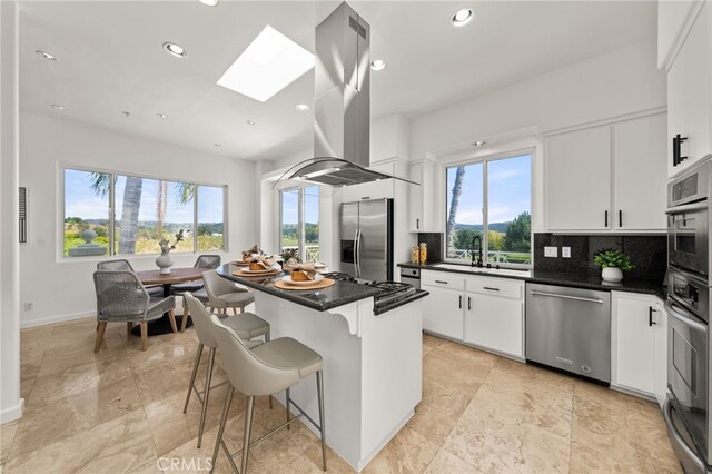 4462 Fallsbrae Rd, Fallbrook, CA 92028 - kitchen with appliances with stainless steel finishes, island range hood, a skylight, healthy amount of natural light, and recessed lighting
